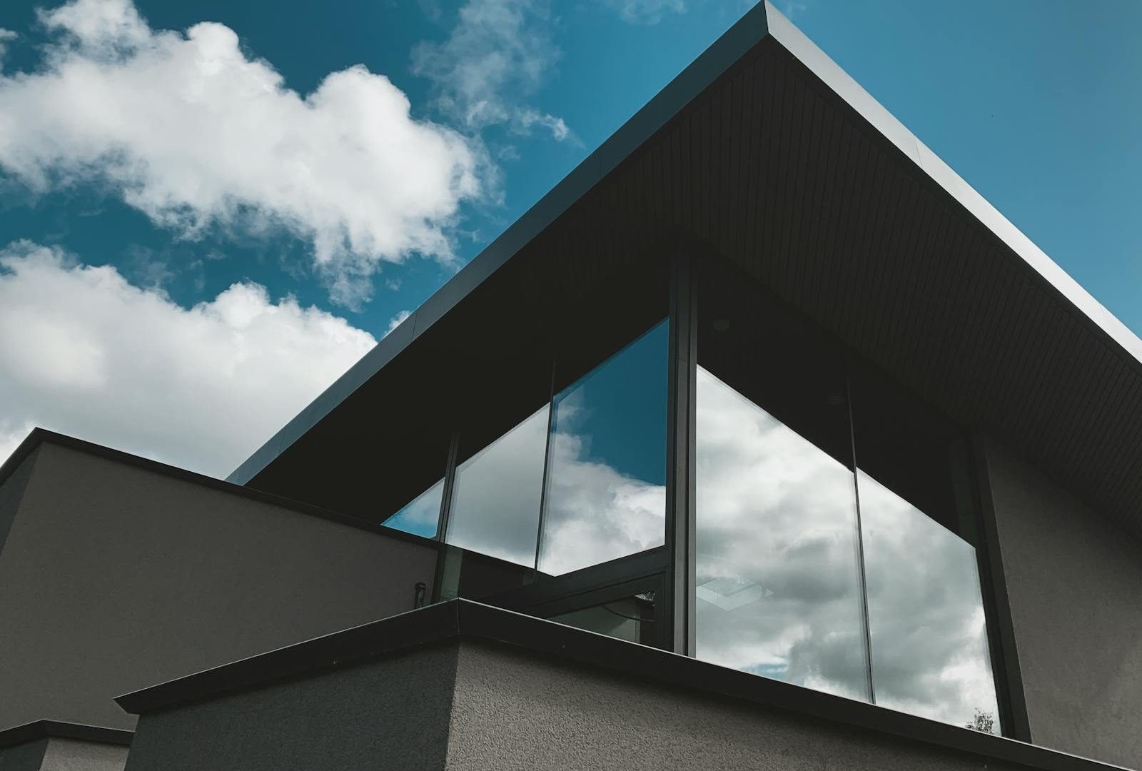 Contemporary architectural facade with glass reflections against a bright sky in Alkmaar, Netherlands.